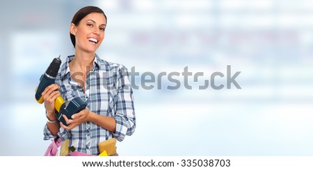 Young woman with a drill. House renovation blue background.