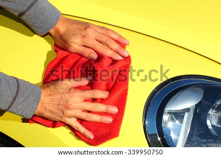 Hand with cloth washing a car. Waxing and polishing.