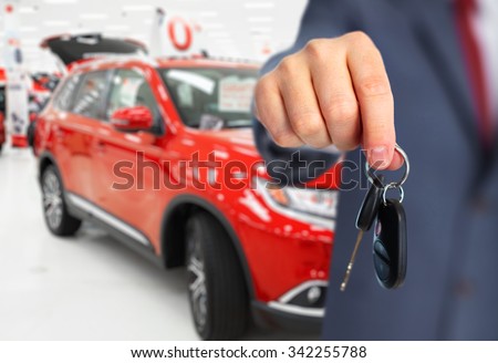 Car dealer with a key. Auto dealership and rental concept background.