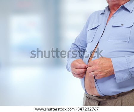 Senior man with big fat stomach over blue background. Obesity concept.