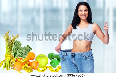 Slimming woman wearing big pants over blue background.