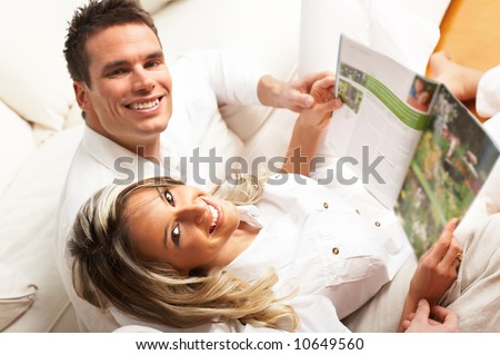 Young love couple reading magazine  in the comfortable apartment