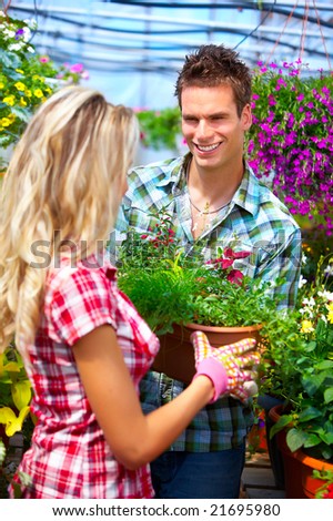 Young smiling people florists working in the garden