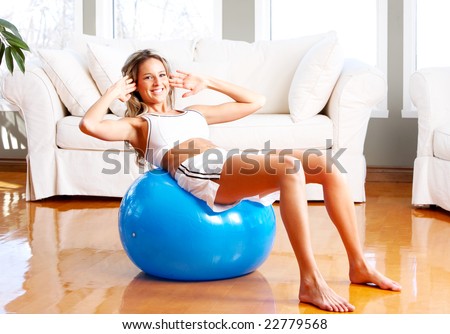 Young woman working out  in the sunny room. Fitness