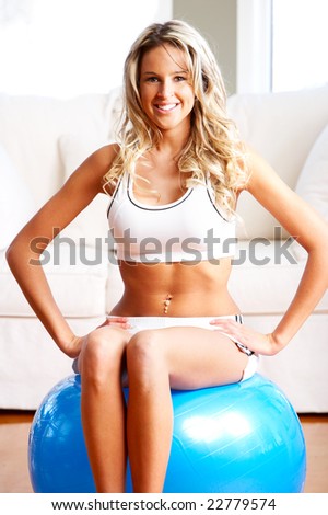Young woman working out  in the sunny room. Fitness