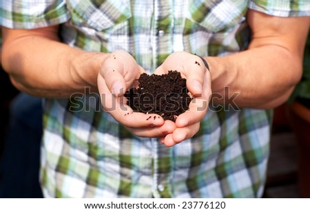 Florist man holding soil in his hands