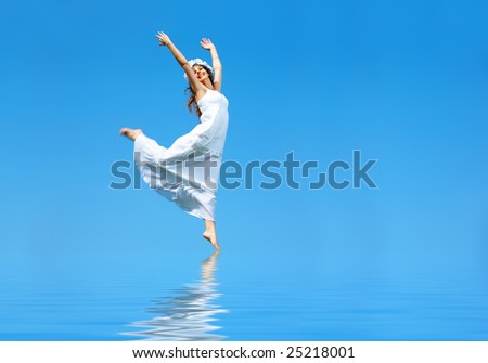 Happy free young woman running across the water