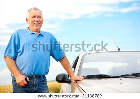 Smiling happy elderly man  and a new car