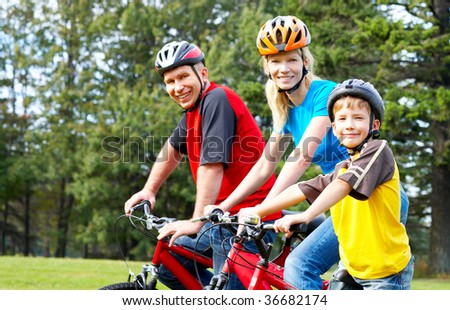 Happy family. Father, mother and son riding  in the park