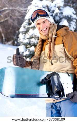 Young  happy smiling man with snowboard. Winter sport