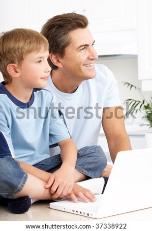 Happy family. Father  and son working with laptop.