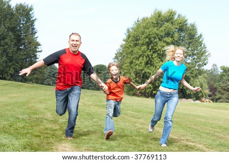 Happy family. Father, mother and sons running  in the park