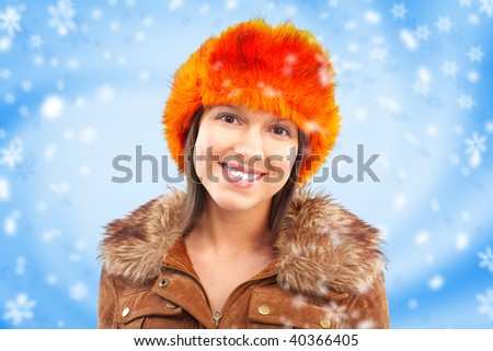 Smiling woman in a fur cap. Over blue background