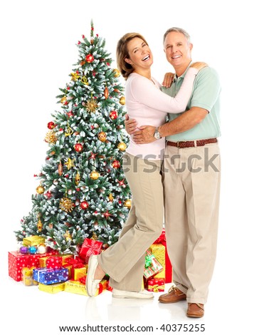 Elderly  happy couple near a Christmas tree. Isolated over white background