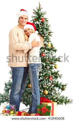 Young happy couple near  a Christmas tree. Over white background