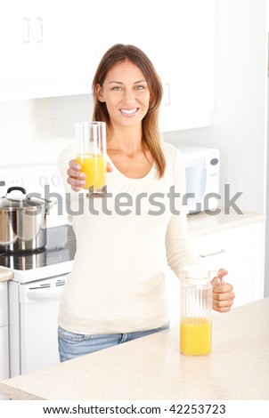 Beautiful smiling woman drinking orange juice