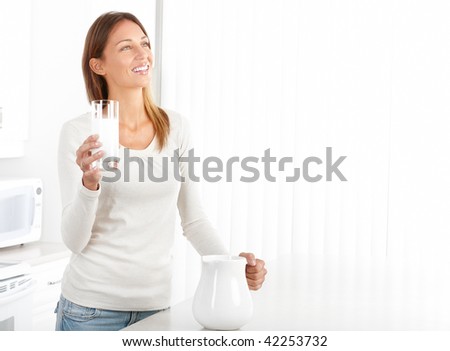 Beautiful smiling woman drinking milk