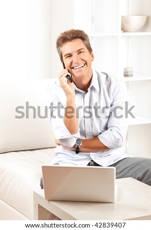 Happy smiling man with laptop at home