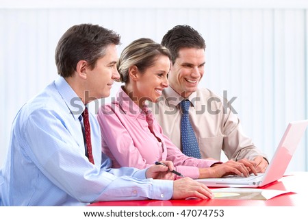Smiling business people team working in the office with laptop