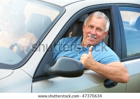 Smiling happy elderly senior  man  in the new car