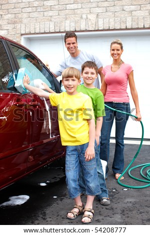 Smiling happy family washing the family car