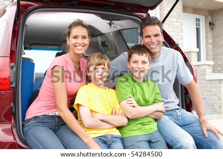 Smiling happy family and a family car