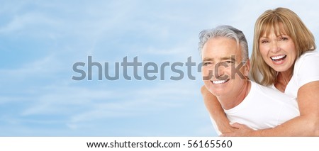 Happy smiling elderly seniors couple under blue sky