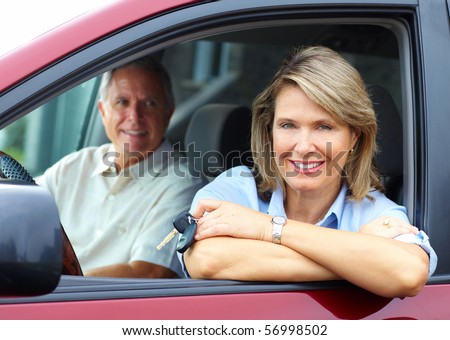 Smiling happy elderly couple in the car