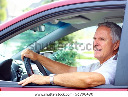 Smiling happy elderly man  in the new car