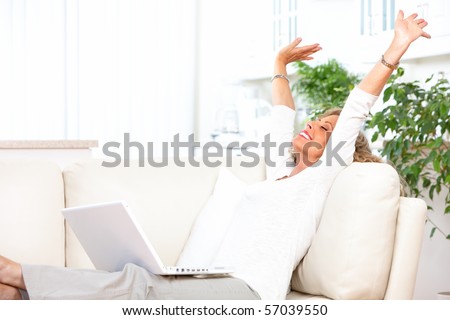 Smiling elderly woman with laptop at home