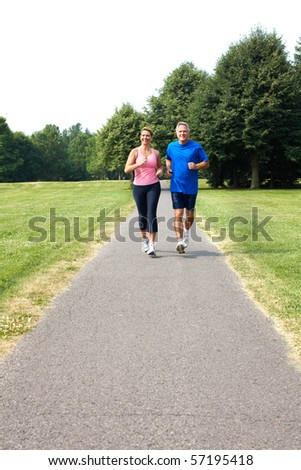 Happy elderly seniors couple jogging in park