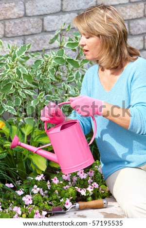 Smiling happy  woman gardening near the home