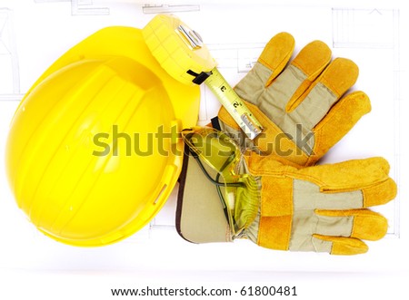 Hard hat, eyeglasses, worker gloves  and ruler over drawing. Renovation tools