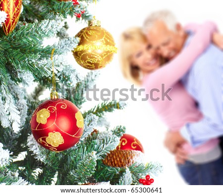 Elderly  happy couple near a Christmas tree. Isolated over white background