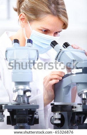 Woman working with a microscope in a lab