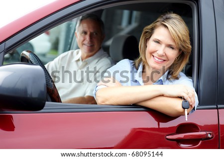 Smiling happy senior couple in the car
