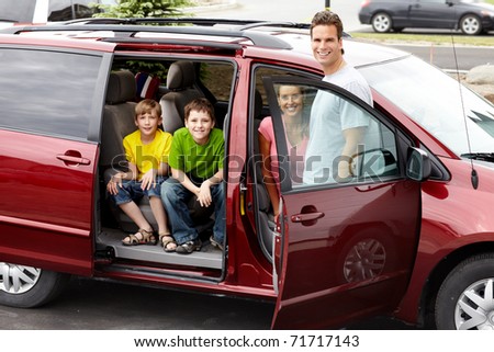 Smiling happy family and a family car