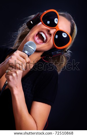 Happy singing woman with headphones  and microphone. Karaoke