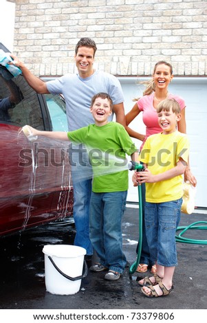 Smiling happy family washing the family car.