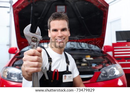 Handsome mechanic working in auto repair shop.