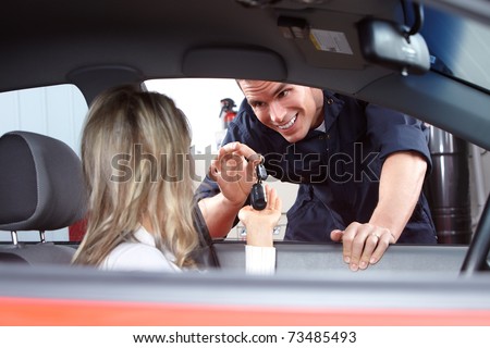 Mechanic handing woman automobile keys. Auto repair