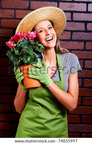 Gardening. Smiling beautiful woman worker with flowers.