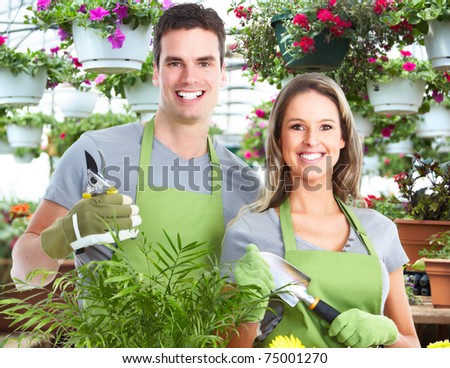 Gardening. People workers with flowers in garden.