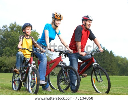 Happy family. Father, mother and son riding  in the park