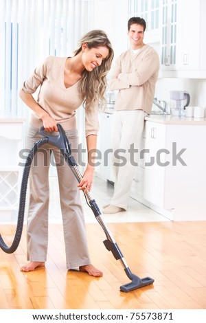 House work vacuum cleaner young couple home kitchen. Housework