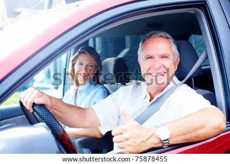 Smiling happy senior couple in the car