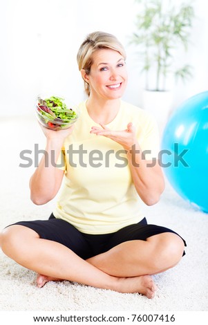 Mature smiling woman  with salad,  fruits and vegetables.