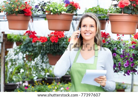 Young woman florist working in plant nursery.
