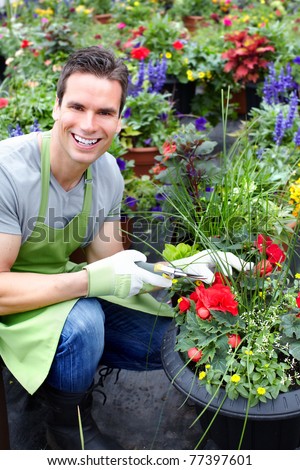 Young smiling florist working in the greenhouse.
