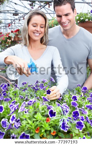 Young smiling people florists working in the greenhouse.